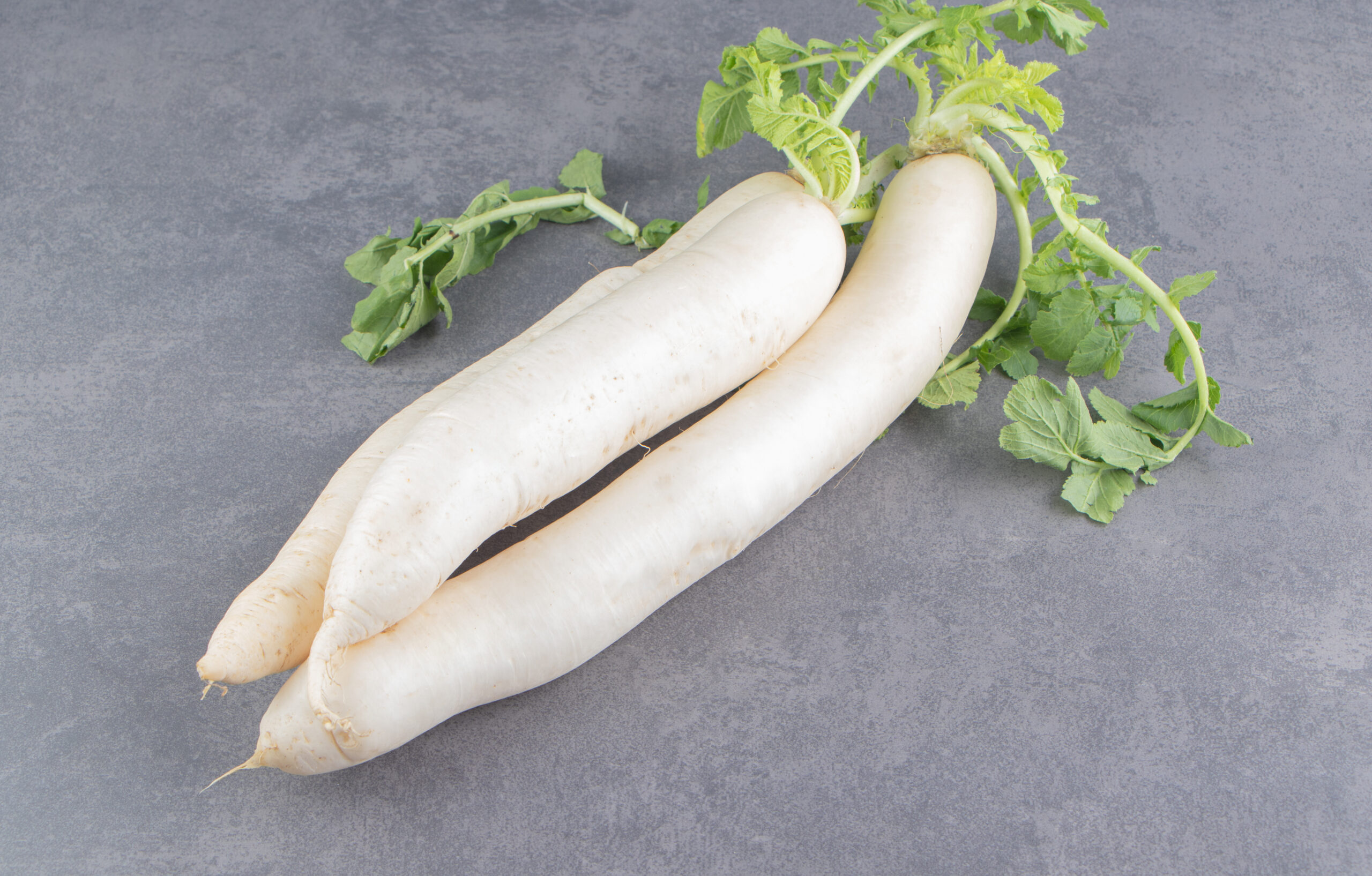 A stack of white radishes on the marble background. High quality photo